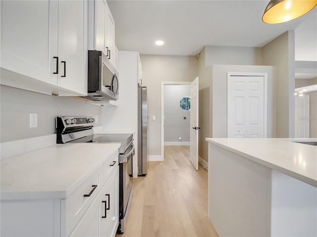 2823 NE 24th Pl, Ocala, FL 34470 - kitchen with stainless steel appliances, light wood-style floors, white cabinets, light countertops, and recessed lighting