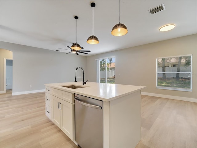 2823 NE 24th Pl, Ocala, FL 34470 - kitchen with stainless steel dishwasher, light wood-style flooring, light countertops, pendant lighting, and arched walkways