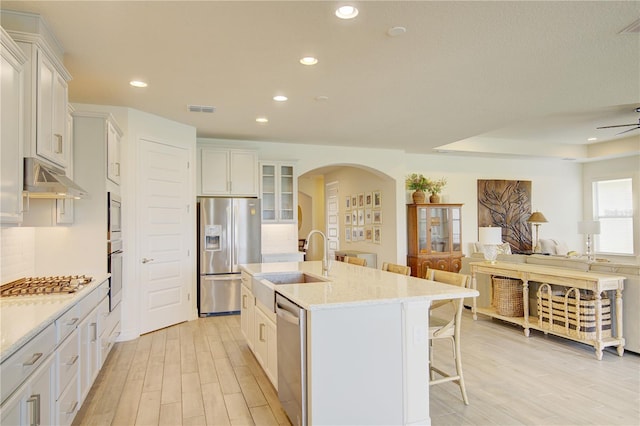 1774 Pasture Loop, Oviedo, FL 32765 - kitchen featuring stainless steel appliances, arched walkways, a kitchen bar, an island with sink, and open floor plan