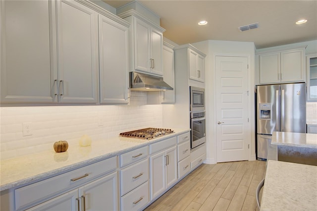 1774 Pasture Loop, Oviedo, FL 32765 - kitchen with appliances with stainless steel finishes, under cabinet range hood, backsplash, light wood finished floors, and recessed lighting