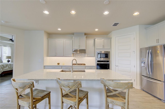 1774 Pasture Loop, Oviedo, FL 32765 - kitchen with appliances with stainless steel finishes, under cabinet range hood, tasteful backsplash, recessed lighting, and light wood finished floors