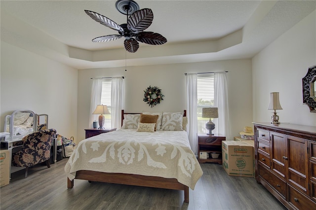1774 Pasture Loop, Oviedo, FL 32765 - bedroom featuring a tray ceiling, multiple windows, wood finished floors, and a ceiling fan