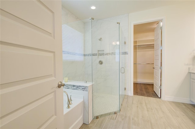 1774 Pasture Loop, Oviedo, FL 32765 - full bathroom featuring a shower stall, a bath, wood finished floors, a walk in closet, and vanity