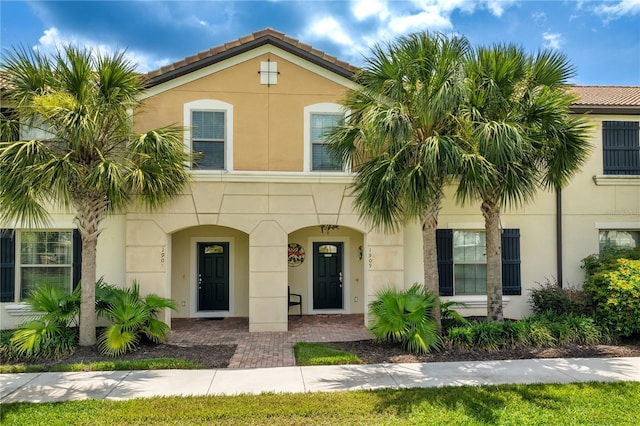 1909 Majorca Dr, Kissimmee, FL 34747 - view of property featuring stucco siding, a porch, and a tiled roof