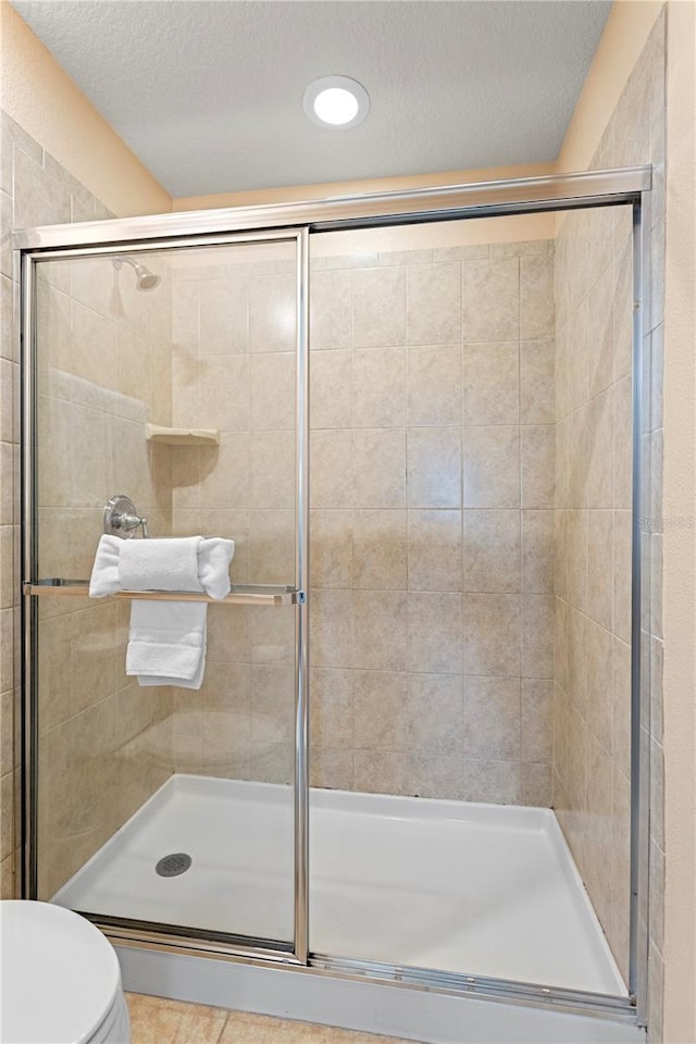 1909 Majorca Dr, Kissimmee, FL 34747 - bathroom with a stall shower, a textured ceiling, tile patterned flooring, and recessed lighting