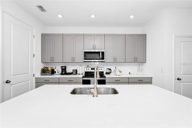 812 Benoi Dr, Davenport, FL 33896 - kitchen featuring stainless steel appliances, gray cabinets, light countertops, and recessed lighting