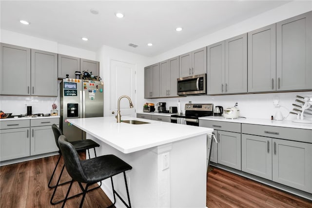 812 Benoi Dr, Davenport, FL 33896 - kitchen featuring stainless steel appliances, gray cabinetry, a breakfast bar, decorative backsplash, and recessed lighting