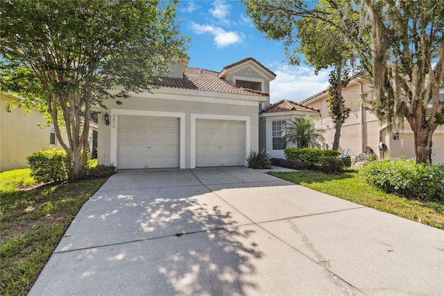 2616 Bowring St, Kissimmee, FL 34747 - mediterranean / spanish house featuring a garage, stucco siding, concrete driveway, and a tile roof