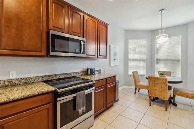 2616 Bowring St, Kissimmee, FL 34747 - kitchen featuring appliances with stainless steel finishes, decorative light fixtures, light stone counters, and light tile patterned flooring
