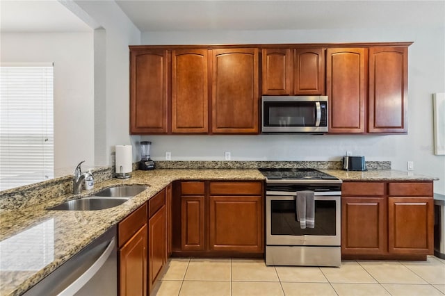 2616 Bowring St, Kissimmee, FL 34747 - kitchen with appliances with stainless steel finishes, light stone counters, light tile patterned flooring, and dark brown cabinets