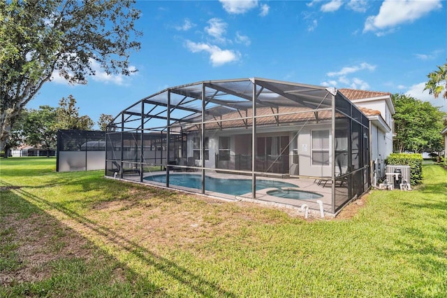 2616 Bowring St, Kissimmee, FL 34747 - rear view of property featuring a lawn, a pool with connected hot tub, a patio area, and a lanai