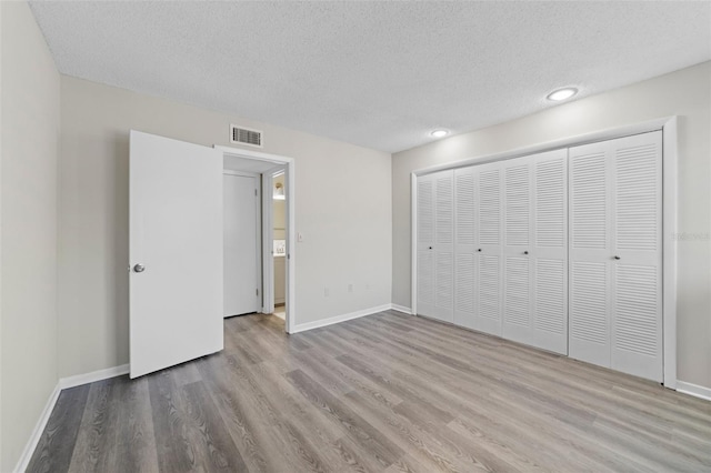 6120 Peregrine Ave Unit A08-2, Orlando, FL 32819 - unfurnished bedroom with wood finished floors, a textured ceiling, a closet, and recessed lighting