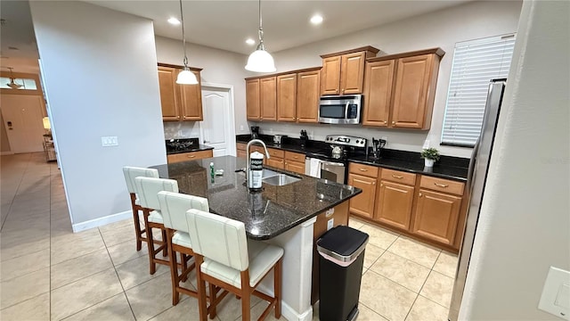8940 Sugar Palm Rd, Kissimmee, FL 34747 - kitchen with appliances with stainless steel finishes, a center island with sink, light tile patterned flooring, a breakfast bar area, and recessed lighting