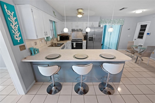 543 Silver Crse, Ocala, FL 34472 - kitchen featuring stainless steel appliances, light countertops, a peninsula, under cabinet range hood, and decorative backsplash