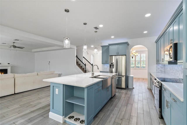 530 Harriswood Ct, Davenport, FL 33837 - kitchen with stainless steel appliances, ceiling fan, open floor plan, arched walkways, and light countertops