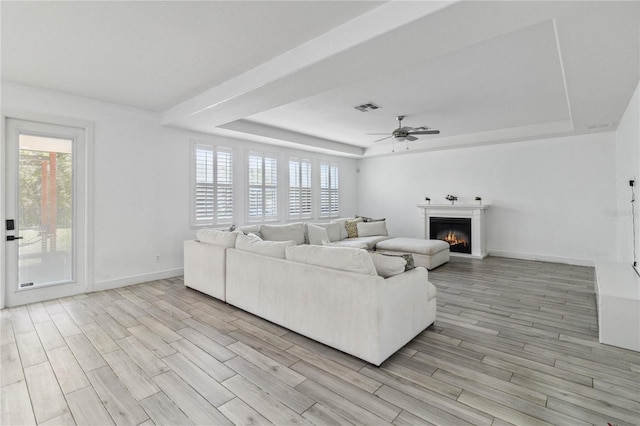 530 Harriswood Ct, Davenport, FL 33837 - living room with a raised ceiling, healthy amount of natural light, a lit fireplace, and a ceiling fan