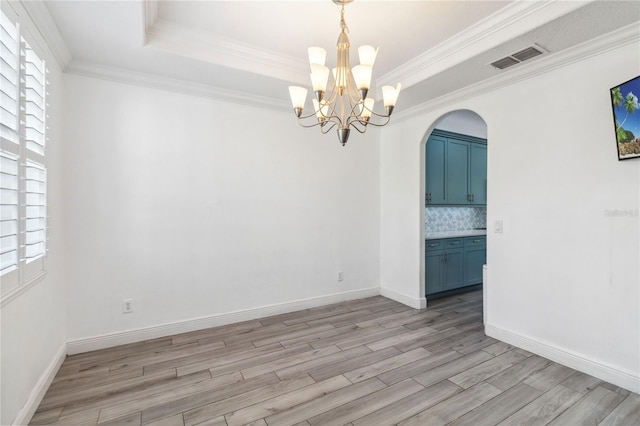 530 Harriswood Ct, Davenport, FL 33837 - spare room with light wood-type flooring, healthy amount of natural light, a chandelier, arched walkways, and ornamental molding