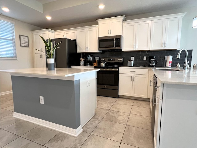 4751 Clock Tower Dr Unit 304, Kissimmee, FL 34746 - kitchen featuring appliances with stainless steel finishes, decorative backsplash, white cabinets, recessed lighting, and a kitchen island