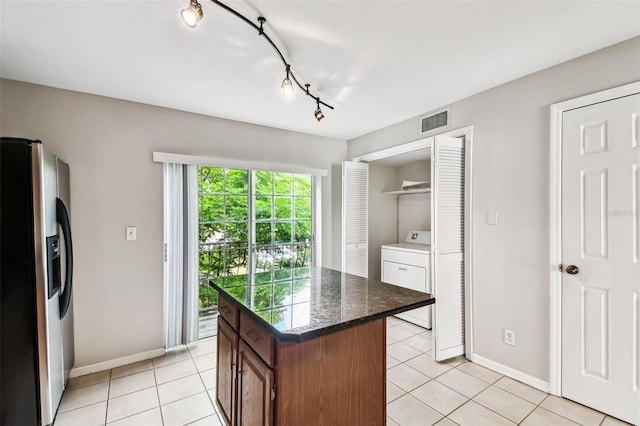 609 S Glen Ave Unit E, Tampa, FL 33609 - kitchen featuring stainless steel fridge, washer / dryer, a center island, and light tile patterned floors