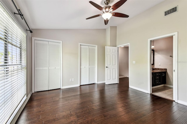 609 S Glen Ave Unit E, Tampa, FL 33609 - unfurnished bedroom with vaulted ceiling, two closets, wood finished floors, ensuite bath, and a ceiling fan
