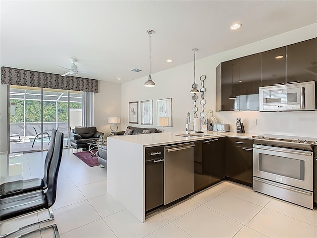 1521 Tranquil Ave, Clermont, FL 34714 - kitchen with stainless steel appliances, a peninsula, open floor plan, light countertops, and pendant lighting