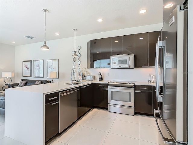 1521 Tranquil Ave, Clermont, FL 34714 - kitchen featuring stainless steel appliances, a peninsula, open floor plan, hanging light fixtures, and light countertops