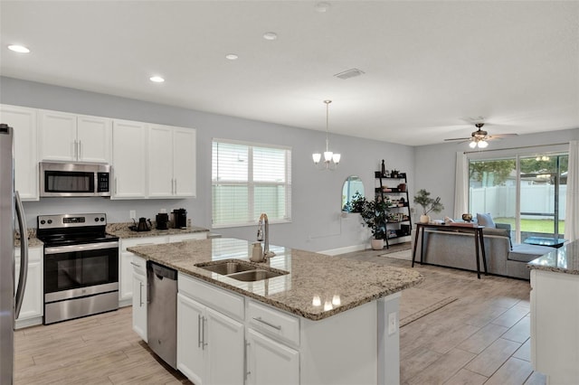 1061 Castlevecchio Loop, Orlando, FL 32825 - kitchen featuring stainless steel appliances, plenty of natural light, white cabinets, light wood-type flooring, and recessed lighting