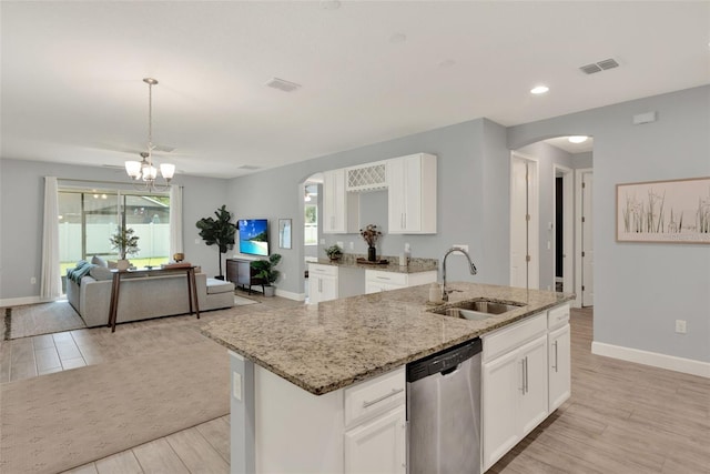 1061 Castlevecchio Loop, Orlando, FL 32825 - kitchen featuring stainless steel dishwasher, arched walkways, light wood-style floors, light stone counters, and a chandelier