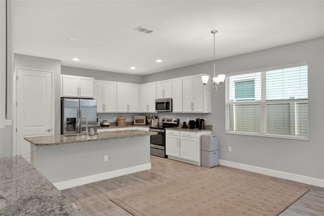 1061 Castlevecchio Loop, Orlando, FL 32825 - kitchen featuring stainless steel appliances, light wood-style floors, recessed lighting, white cabinetry, and light stone countertops