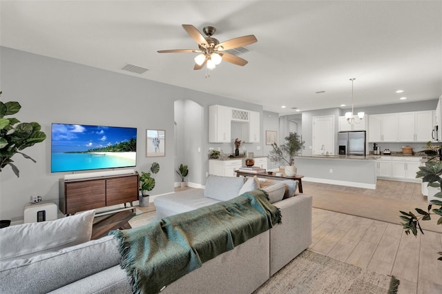 1061 Castlevecchio Loop, Orlando, FL 32825 - living area with arched walkways, recessed lighting, a ceiling fan, light wood-type flooring, and a chandelier