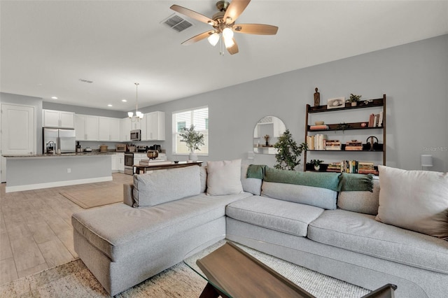1061 Castlevecchio Loop, Orlando, FL 32825 - living room with light wood finished floors, recessed lighting, ceiling fan, and a chandelier