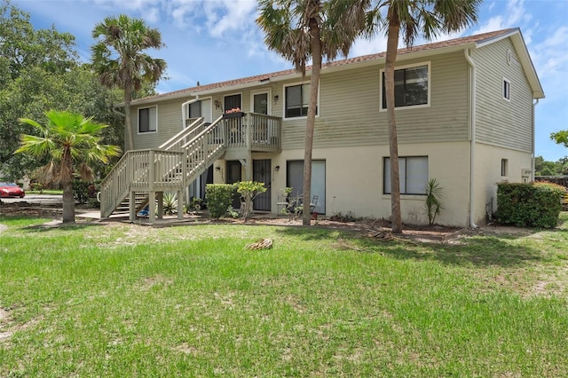 7344 Swallow Run Unit 7344, Winter Park, FL 32792 - back of house with stairway, a lawn, and stucco siding