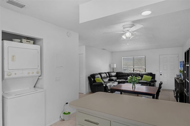 7344 Swallow Run Unit 7344, Winter Park, FL 32792 - washroom featuring stacked washer and clothes dryer, light tile patterned flooring, ceiling fan, and a textured ceiling