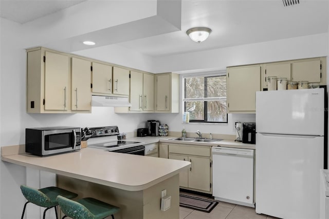7344 Swallow Run Unit 7344, Winter Park, FL 32792 - kitchen featuring white appliances, cream cabinets, under cabinet range hood, light countertops, and a peninsula