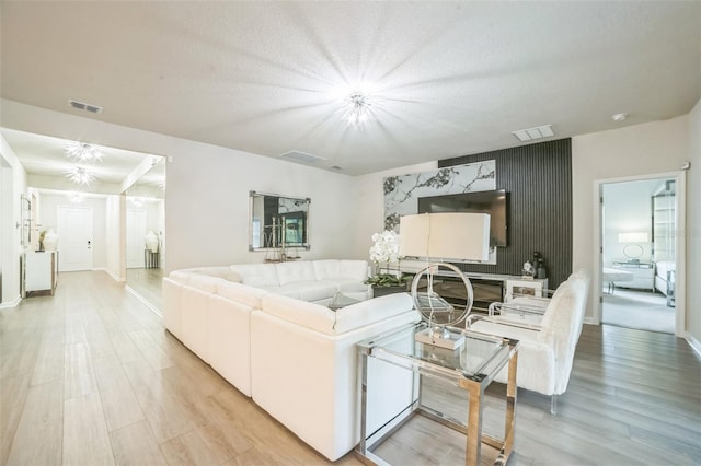 730 Rominger Loop, Apopka, FL 32712 - living area with light wood-type flooring, an accent wall, a chandelier, and a textured ceiling