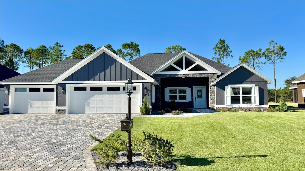 6449 SW 180th Cir, Dunnellon, FL 34432 - view of front of home with board and batten siding, stone siding, a garage, and a front lawn