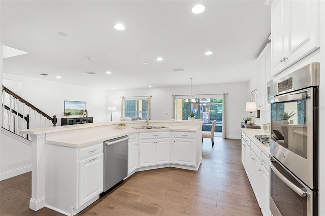 2432 Riviera Ln, Minneola, FL 34715 - kitchen with appliances with stainless steel finishes, recessed lighting, light wood finished floors, light countertops, and white cabinetry