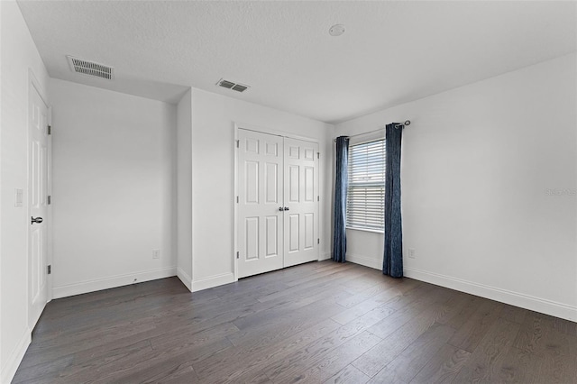 2432 Riviera Ln, Minneola, FL 34715 - unfurnished bedroom featuring dark wood-style floors, a closet, and a textured ceiling