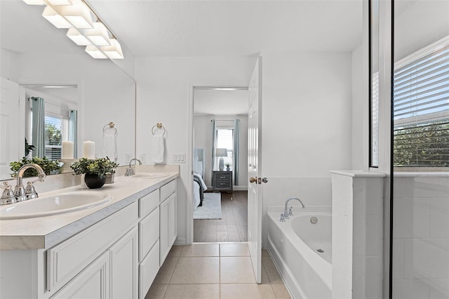 2432 Riviera Ln, Minneola, FL 34715 - ensuite bathroom featuring healthy amount of natural light, double vanity, a garden tub, and tile patterned floors