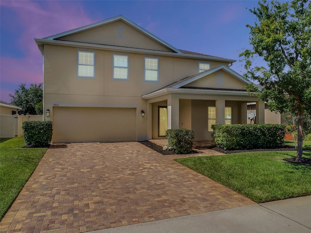 2432 Riviera Ln, Minneola, FL 34715 - traditional-style home featuring stucco siding, decorative driveway, and a garage