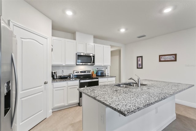 5808 Arboretum St, Saint Cloud, FL 34771 - kitchen featuring appliances with stainless steel finishes, white cabinets, light stone counters, recessed lighting, and a kitchen island with sink
