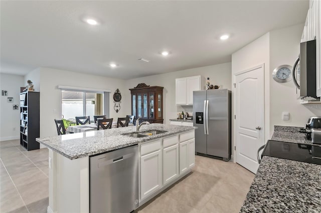 5808 Arboretum St, Saint Cloud, FL 34771 - kitchen with stainless steel appliances, an island with sink, white cabinetry, light stone counters, and recessed lighting