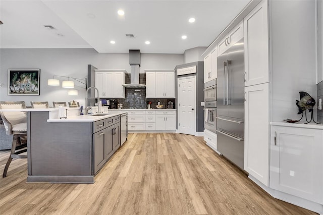 3316 Regal Crest Dr, Longwood, FL 32779 - kitchen featuring wall chimney exhaust hood, white cabinets, light wood finished floors, and recessed lighting