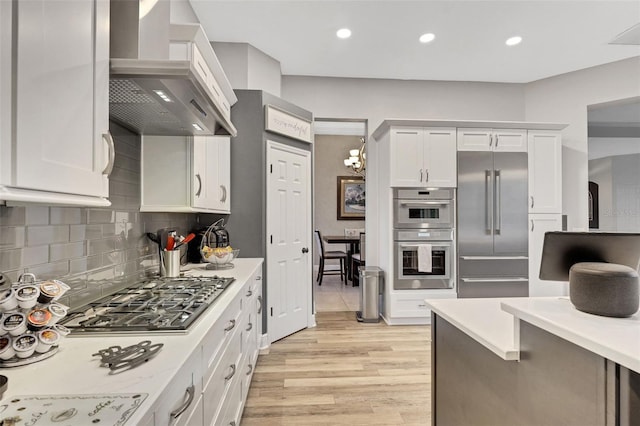 3316 Regal Crest Dr, Longwood, FL 32779 - kitchen with range hood, stainless steel appliances, light wood-type flooring, light countertops, and tasteful backsplash