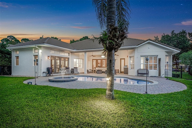 3316 Regal Crest Dr, Longwood, FL 32779 - back of property at dusk with french doors, ceiling fan, stucco siding, a patio area, and an in-ground hot tub