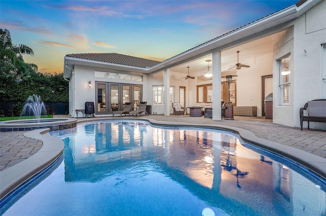 3316 Regal Crest Dr, Longwood, FL 32779 - pool at dusk with french doors, a patio area, a pool with connected hot tub, and outdoor lounge area