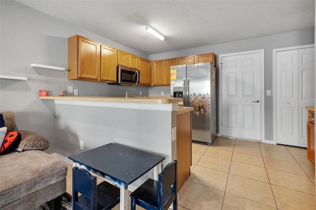509 Cresting Oak Cir Unit 73, Orlando, FL 32824 - kitchen with appliances with stainless steel finishes, light tile patterned floors, a peninsula, light countertops, and open shelves