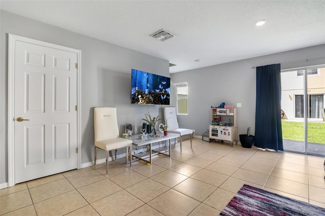 509 Cresting Oak Cir Unit 73, Orlando, FL 32824 - living room featuring light tile patterned floors, plenty of natural light, and a textured ceiling