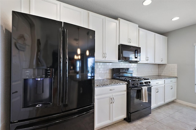 1292 Cavender Creek Rd, Minneola, FL 34715 - kitchen with black appliances, light stone counters, backsplash, white cabinets, and light tile patterned floors