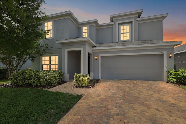 1292 Cavender Creek Rd, Minneola, FL 34715 - view of front of property with stucco siding, an attached garage, and decorative driveway